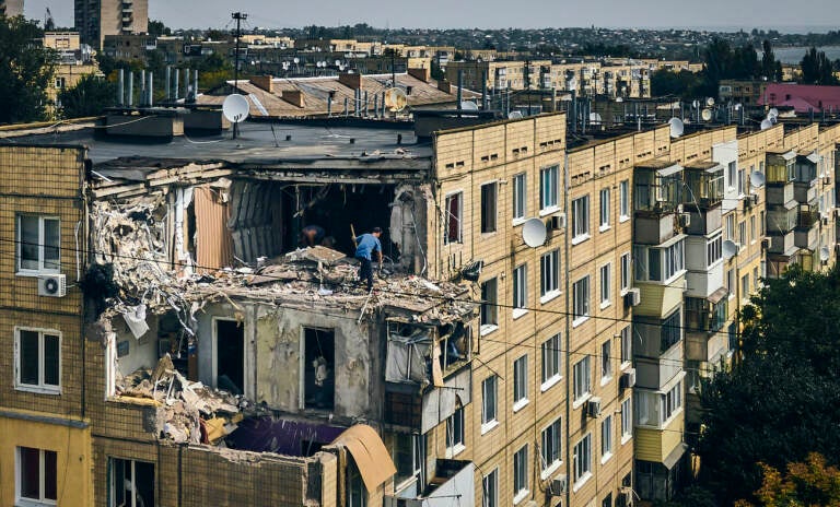 A man cleans an apartment destroyed after Russian shelling in Nikopol, Ukraine, Monday, Aug. 15, 2022. (AP Photo/Kostiantyn Liberov)