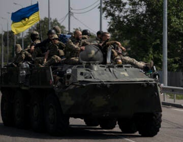 Ukrainian servicemen ride atop of an armored vehicle on a road in Donetsk region, eastern Ukraine, Sunday, Aug. 28, 2022. (AP Photo/Leo Correa)