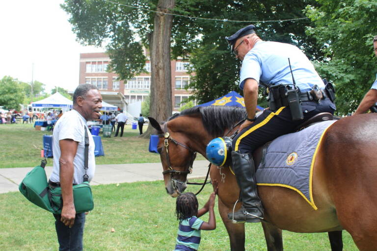 Attendants at Philadelphia’s First Responders Day interact with a mounted police officer and his horse. (Cory Sharber/WHYY)