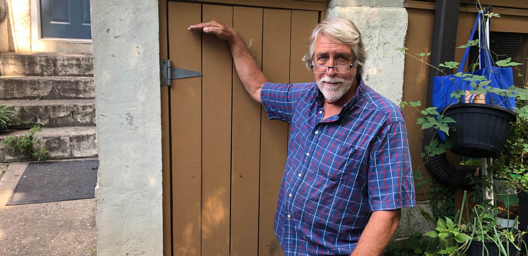 Nelson Haakenson points to the level water reached on his basement door during Ida (Sophia Schmidt/WHYY)