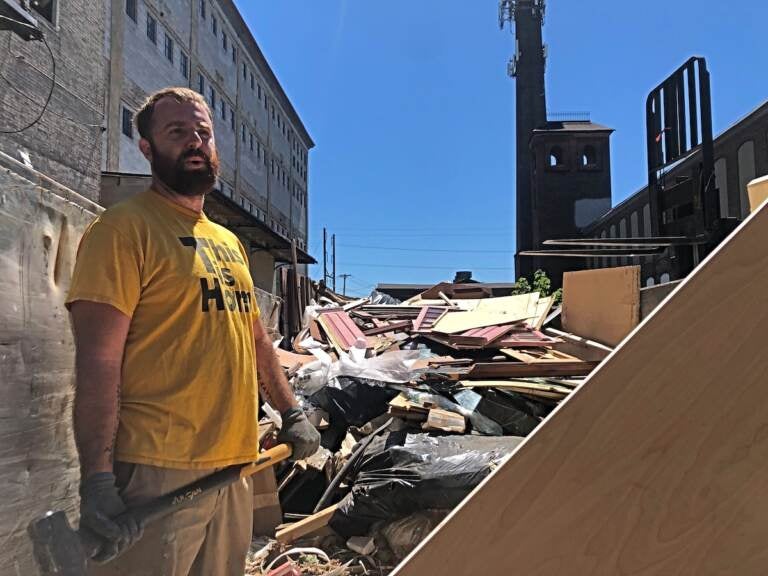 Greg Trainor, executive director of Philly Reclaim, was chopping up scraps as they cleared out the warehouse in its final days. (Emily Rizzo / WHYY)