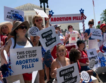 Abortion-rights activists setup an abortion pills educational booth as they protest outside the Supreme Court in Washington, Monday, July 4, 2022. The Supreme Court has ended constitutional protections for abortion that had been in place nearly 50 years, a decision by its conservative majority to overturn the court's landmark abortion cases. (AP Photo/Jose Luis Magana)