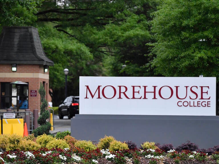 A sign reads Morehouse College, with green trees in the background.