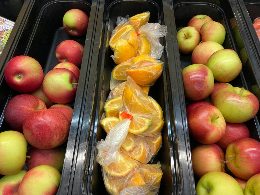 Apples and orange slices rest in trays