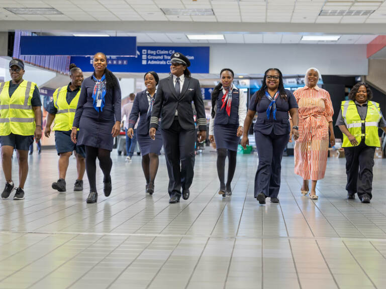 A Black, woman-led crew walks at the airport