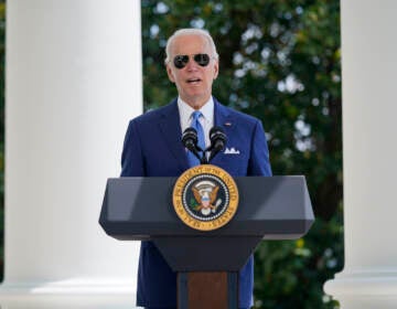 President Biden speaks at a podium wearing sunglasses.