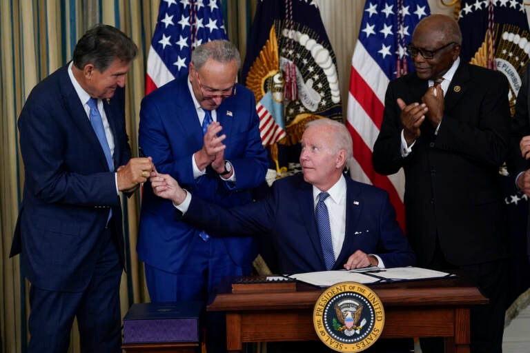 President Joe Biden hands the pen he used to sign the Democrats' landmark climate change and health care bill to Sen. Joe Manchin, D-W.Va., in the State Dining Room of the White House in Washington, Tuesday, Aug. 16, 2022. (AP Photo/Susan Walsh)