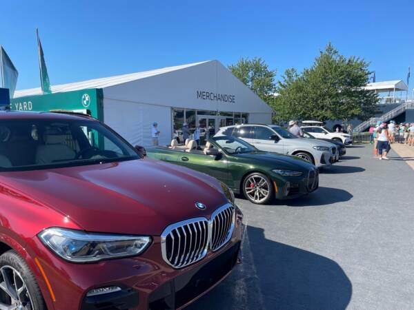 BMW is showcasing its vehicles outside a showroom near the first tee. (Cris Barrish/WHYY)