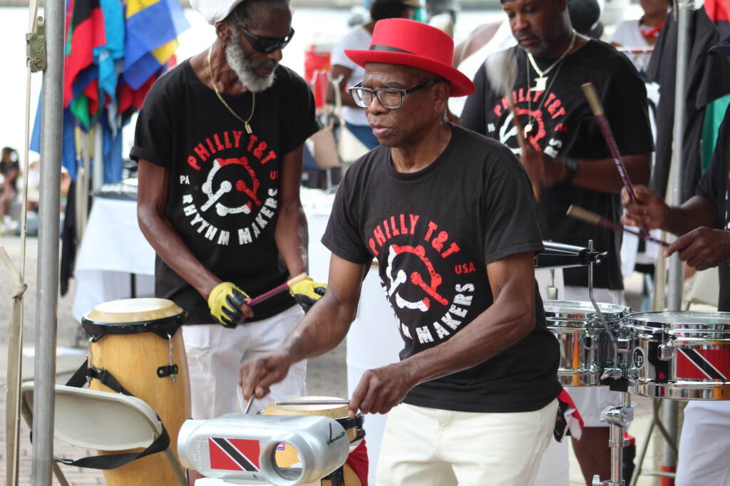 A man plays an instrument alongside members of the band.