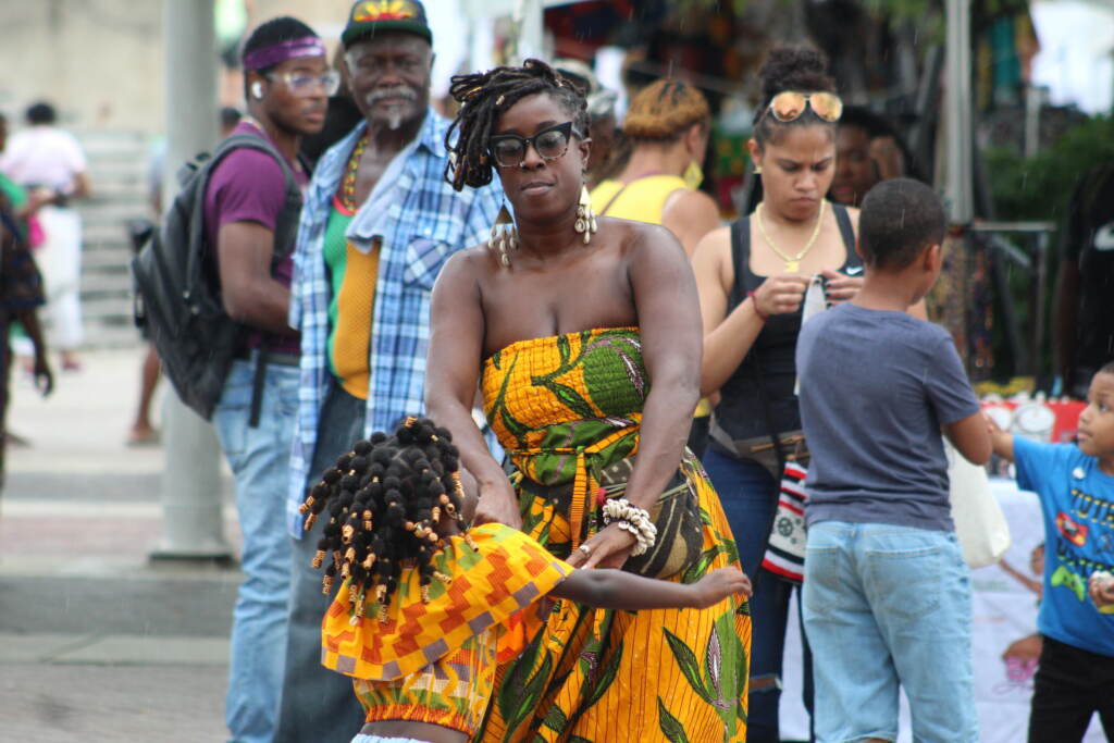 People dance at the Caribbean Fest in Philadelphia as others are visible in the background looking on.