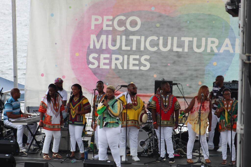 A group of musicians perform onstage in front of a sign that reads, "PECO Multicultural Series."