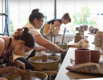 People practice wheelthrowing at the Clay Studio's new facility on North American Street. (WHYY Youth Journalism Camp students)