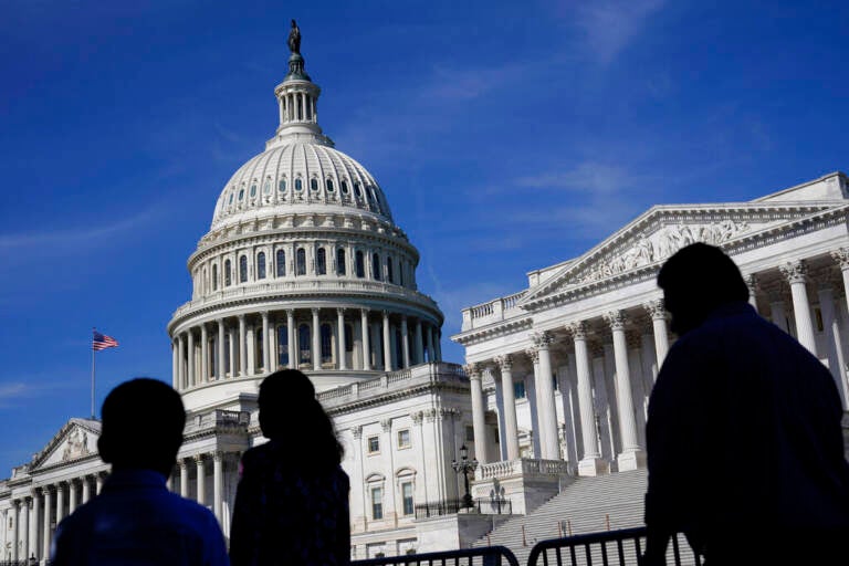 The U.S. Capitol is shown from afar on a sunny day.