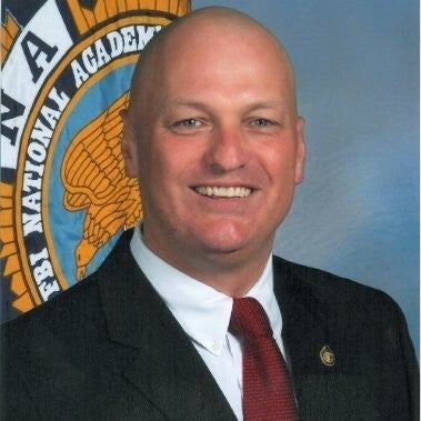 A headshot of Mike Kelly, smiling.