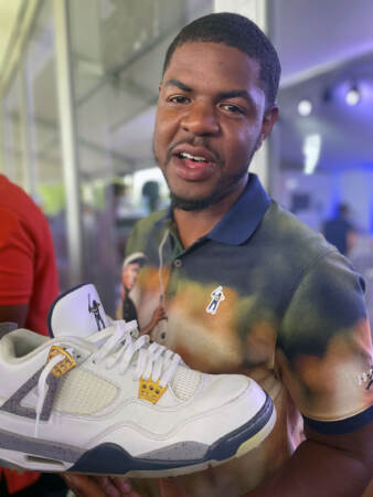 Earl Cooper holds up a sneaker