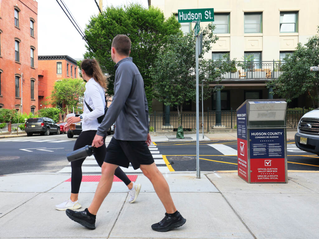 Two people walk down the sidewalk in Hoboken