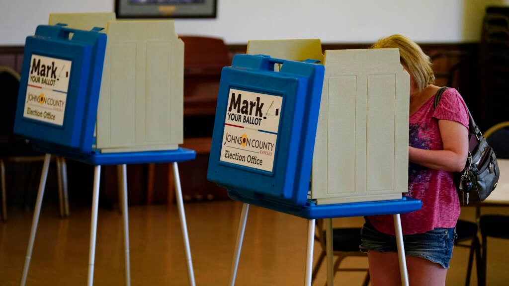 A voter casts a ballot in the Kansas primary