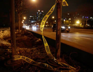Crime scene tape is seen along a street at night