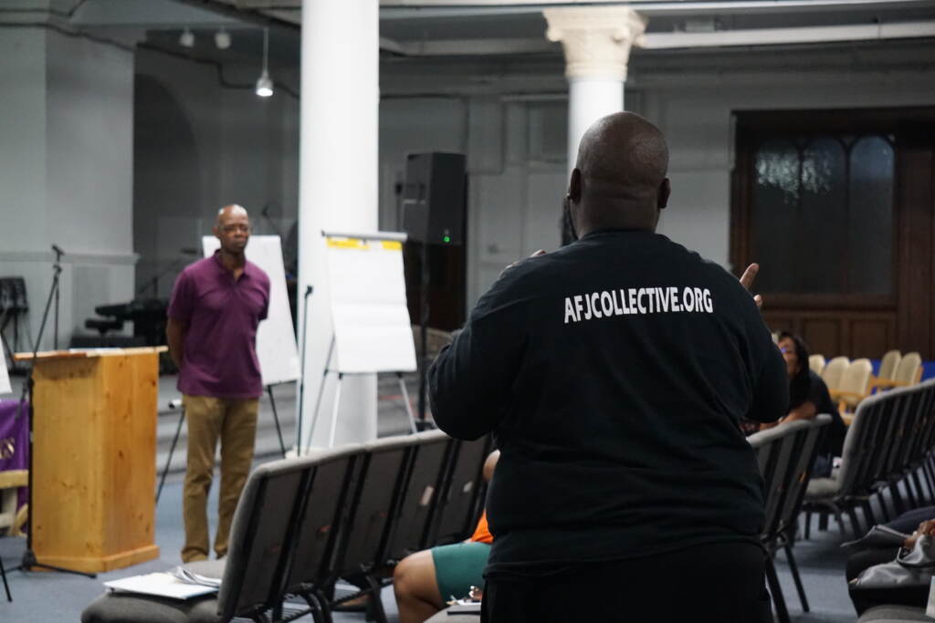 Michael Brown of the Action For Justice Collective takes the mic at a gun violence meeting.