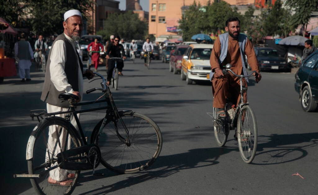 Men ride bicycles in Kabul.