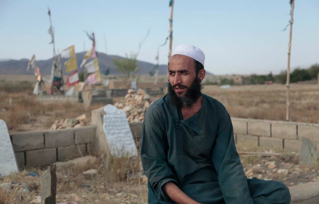 Ahmad Shah sits in the cemetery near his village of Patan Khel