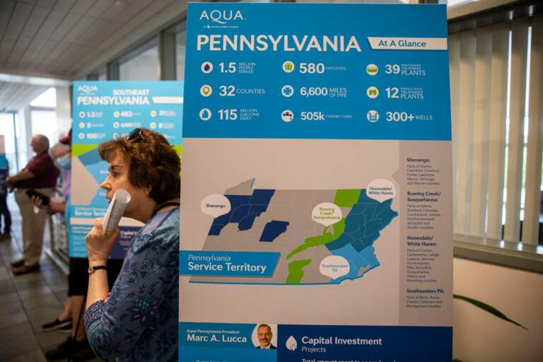 A sign shows a map of Pennsylvania with a person standing behind it.