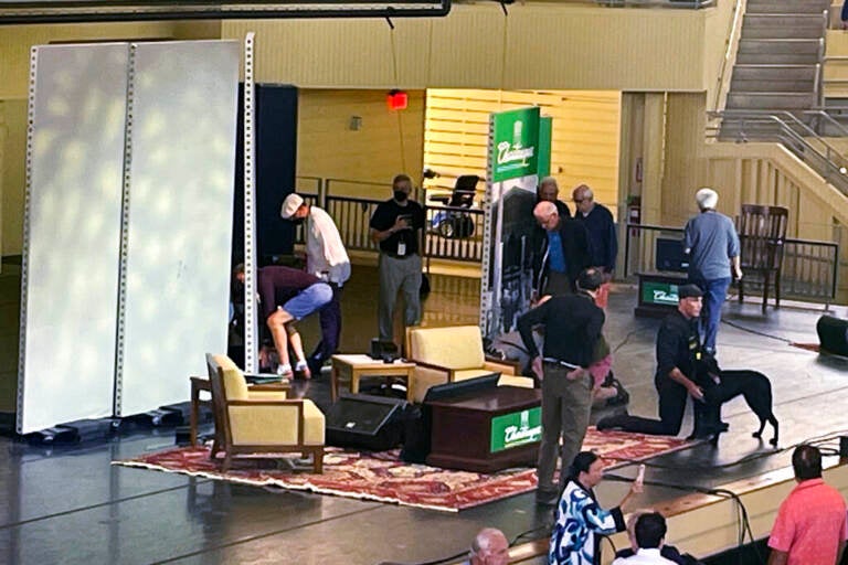 A view from above of many people standing on stage, including security officers.