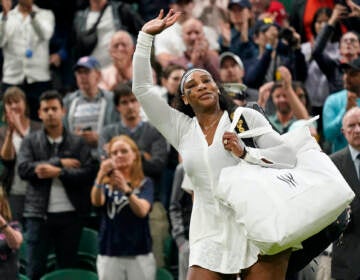 Serena Williams of the US waves as she leaves the court after losing to France's Harmony Tan in a first round women's singles match on day two of the Wimbledon tennis championships in London, Tuesday, June 28, 2022. (AP Photo/Alberto Pezzali)