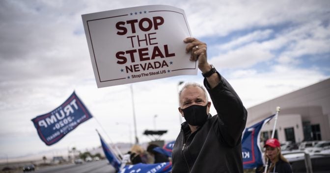 A person holds up a sign that reads, "Stop the Steal."