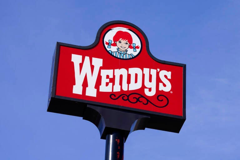 A sign reads Wendys, with a blue sky visible in the background.