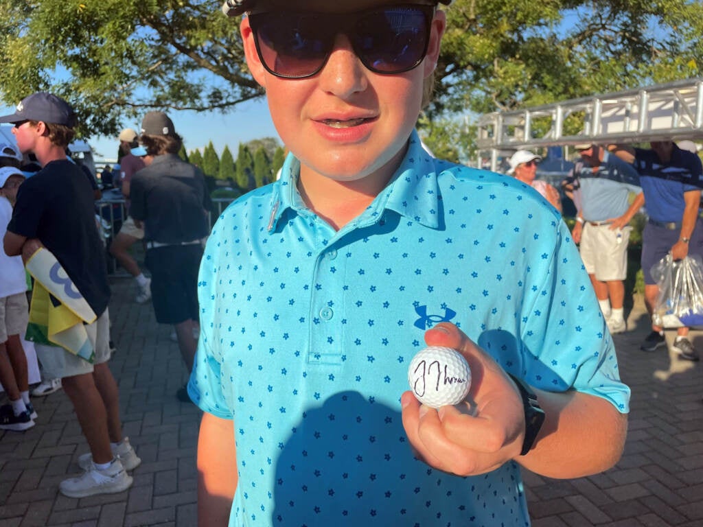 Jack Enslen shows off a golf ball signed by Justin Thomas