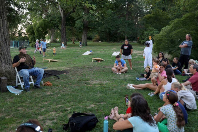 Don Shump presents for a group of attendees at the Philadelphia Honey Festival while covered in honey bees. (Kimberly Paynter/WHYY)