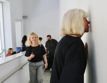 Sissel Tolaas stops to smell a wall imbedded with the recorded and replicated sweat of anxious men at her exhibit ''RE______'' at the Institute of Contemporary Art at Penn. (Emma Lee/WHYY)