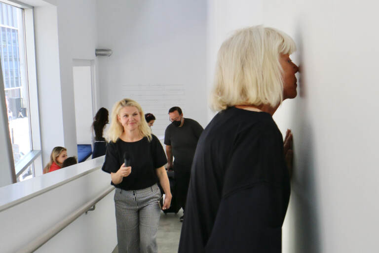 Sissel Tolaas stops to smell a wall imbedded with the recorded and replicated sweat of anxious men at her exhibit ''RE______'' at the Institute of Contemporary Art at Penn. (Emma Lee/WHYY)