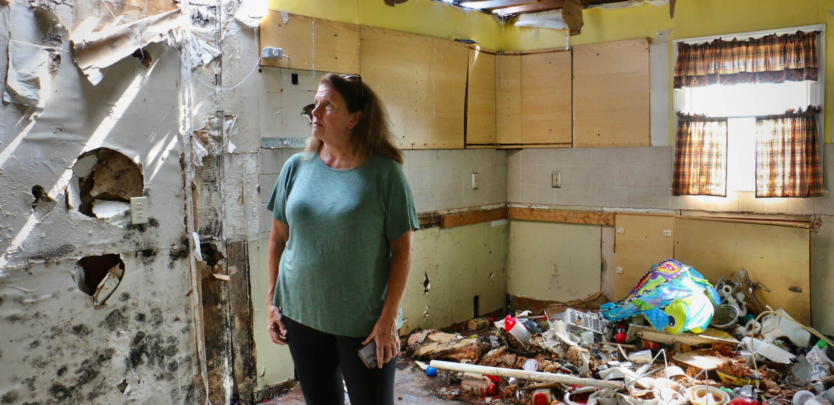 Tammy Echevaria stands in the kitchen of her home, damaged by a tornado