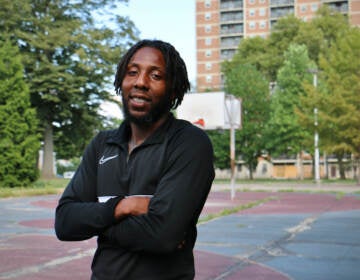 Reggie Johnson stands on the basketball court at Fotteral Square Park. He is optimistic that the Rebuild of the park and the renovation of the Fairhill Apartments for senior housing will make the neighborhood safer. (Emma Lee/WHYY)