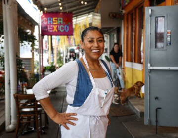 Cristina Martínez at her restaurant Casa Mexico. The lightbox outside honors her late son, Isaias Berriozabal-Martínez, with a poem he wrote. (Kimberly Paynter/WHYY)