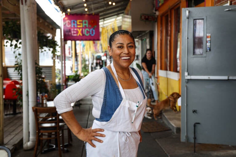 Cristina Martínez at her restaurant Casa Mexico. The lightbox outside honors her late son, Isaias Berriozabal-Martínez, with a poem he wrote. (Kimberly Paynter/WHYY)