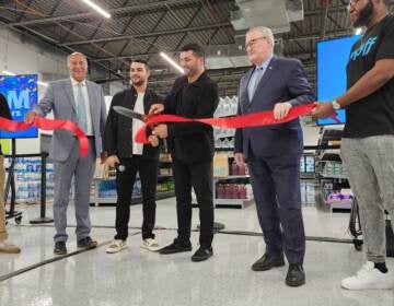 Gopuff co-founder Rafael Ilishayev cuts the ribbon on a new distribution facility in Spring Garden, alongside (starting second from left) Philadelphia City Councilmember Mark Squilla, Gopuff cofounder Yakir Gola and Philadelphia Mayor Jim Kenney. (Tom MacDonald/WHYY)