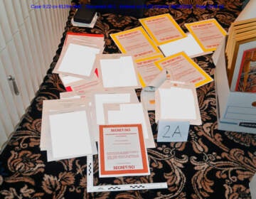 This image contained in a court filing by the Department of Justice on Aug. 30, 2022, and redacted by in part by the FBI, shows a photo of documents seized during the Aug. 8 search by the FBI of former President Donald Trump's Mar-a-Lago estate in Florida. (Department of Justice via AP)