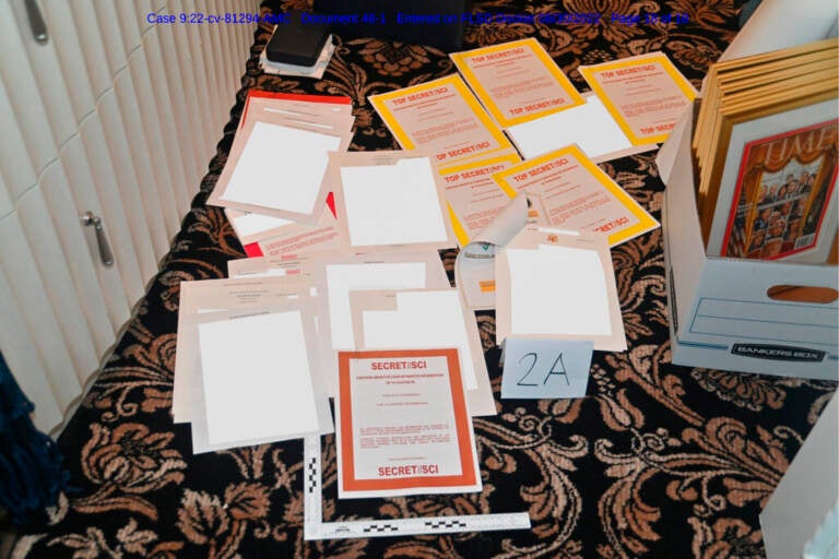 This image contained in a court filing by the Department of Justice on Aug. 30, 2022, and redacted by in part by the FBI, shows a photo of documents seized during the Aug. 8 search by the FBI of former President Donald Trump's Mar-a-Lago estate in Florida. (Department of Justice via AP)