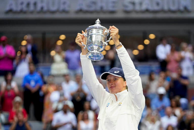 Iga Swiatek, of Poland, holds up the championship trophy after defeating Ons Jabeur, of Tunisia, to win the women's singles final of the U.S. Open tennis championships, Saturday, Sept. 10, 2022, in New York. (AP Photo/Frank Franklin II)