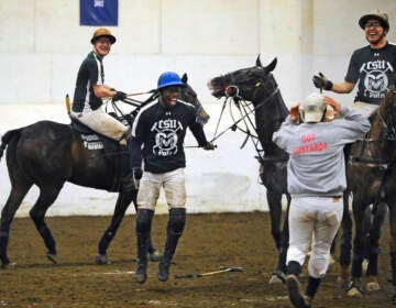 In this Wednesday, April 8, 2015, photo, Colorado State's Kareem Rosser, center, celebrates with his team at the end of a polo match against SMU in the intercollegiate polo championships at the University of Connecticut in Storrs, Conn. Rosser who grew up in poverty in West Philadelphia led Colorado State into the national championship game on Wednesday. About 50 schools field teams in what participants say is no longer just a sport for kings and millionaires. (AP Photo/Jessica Hill)