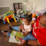 Robin Washington reads to her daughter Delilah. (Cris Barrish/WHYY)
