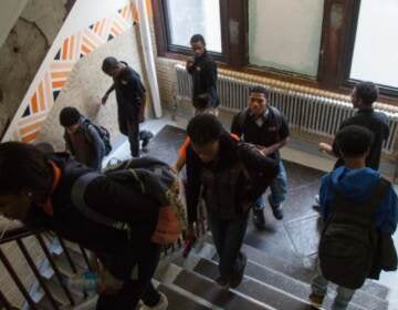 Students pass through a stairwell at Overbrook High School. The school is one of three that will participate in the district’s 21st Century Schools Model initiative where students will pursue workforce training in specific fields related to local needs and interests. (Emily Cohen for WHYY)