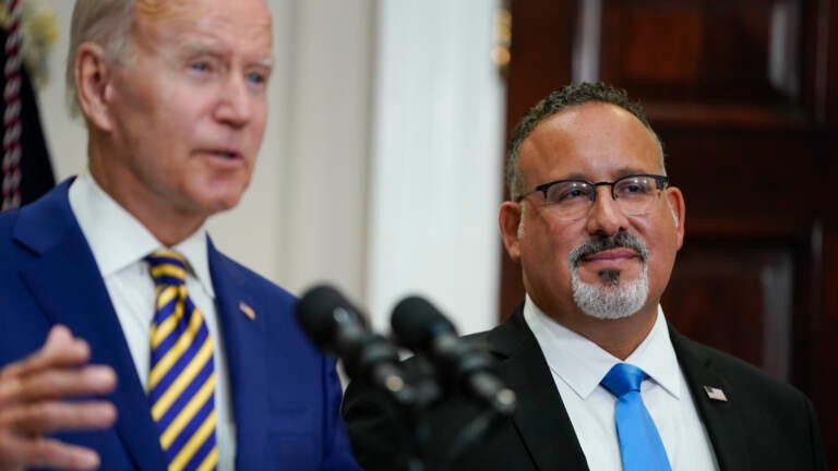 U.S. Education Secretary Miguel Cardona appeared alongside President Biden when he announced his student loan relief plan on Aug. 24. On Thursday, the administration quietly changed its guidance around which borrowers qualify for this relief. (Evan Vucci/AP)