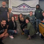 The Pottstown Beacon of Hope team is seen under a banner during a fundraising event.