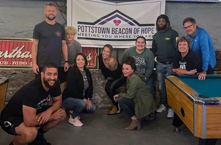 The Pottstown Beacon of Hope team is seen under a banner during a fundraising event.