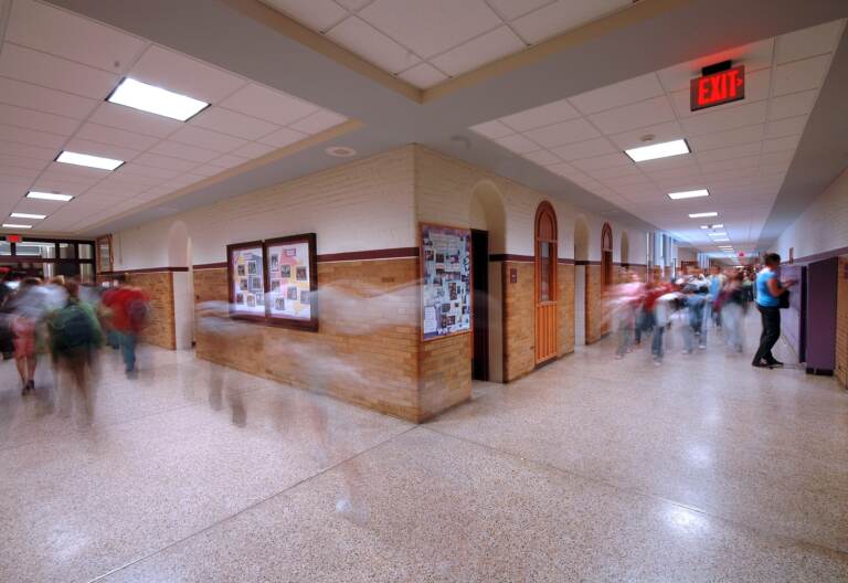 A school hallway with motion blur of students.