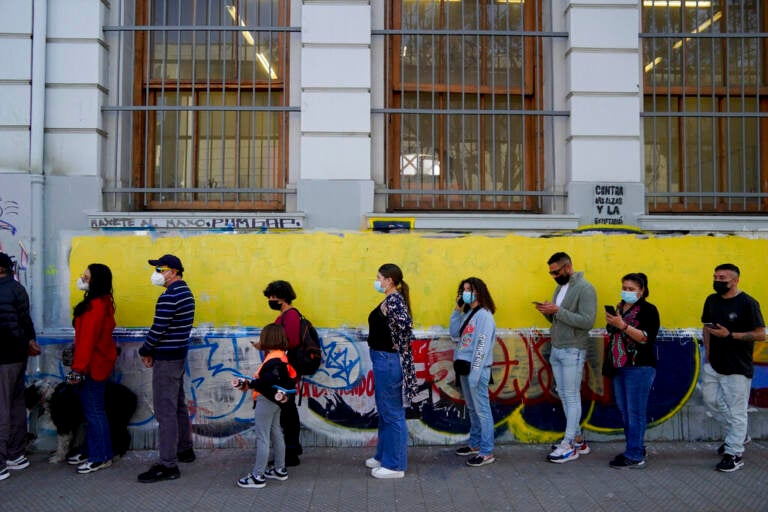 People form a line outside of a building.